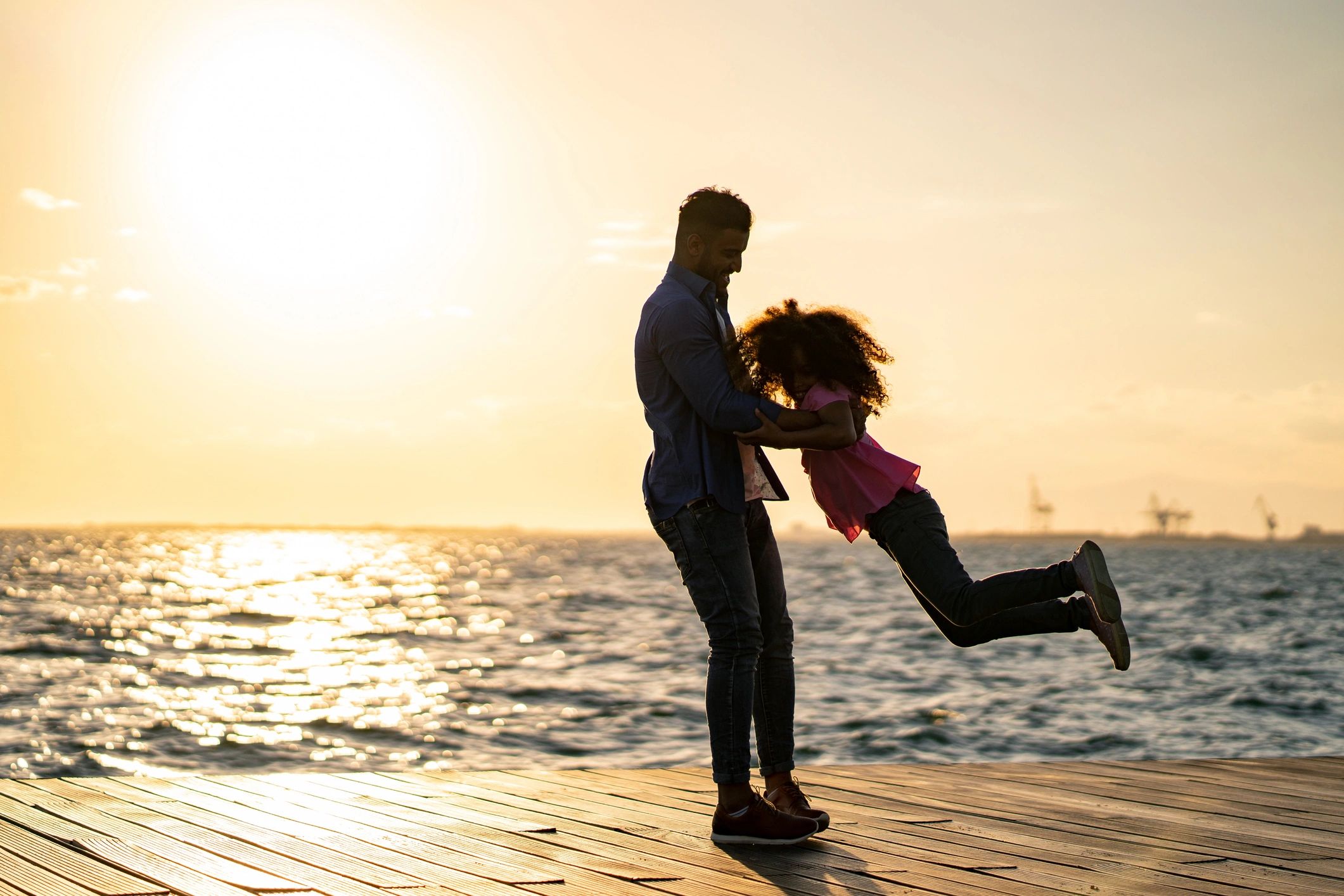Father and daughter sharing a joyful moment by the sea